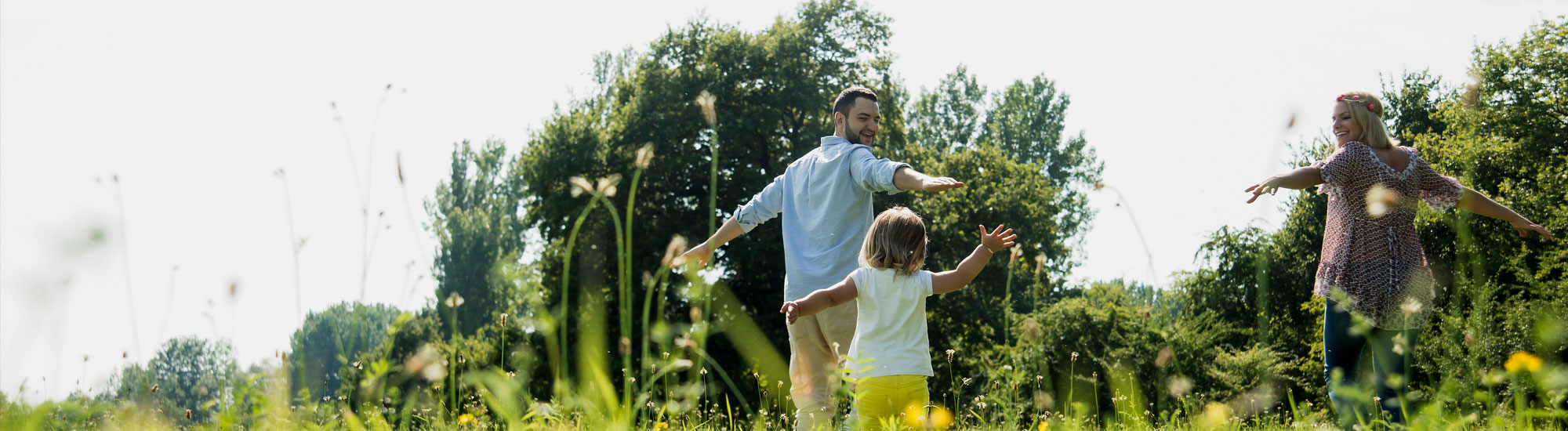Parents and daughter in a field playing Parents and daughter in a field playing